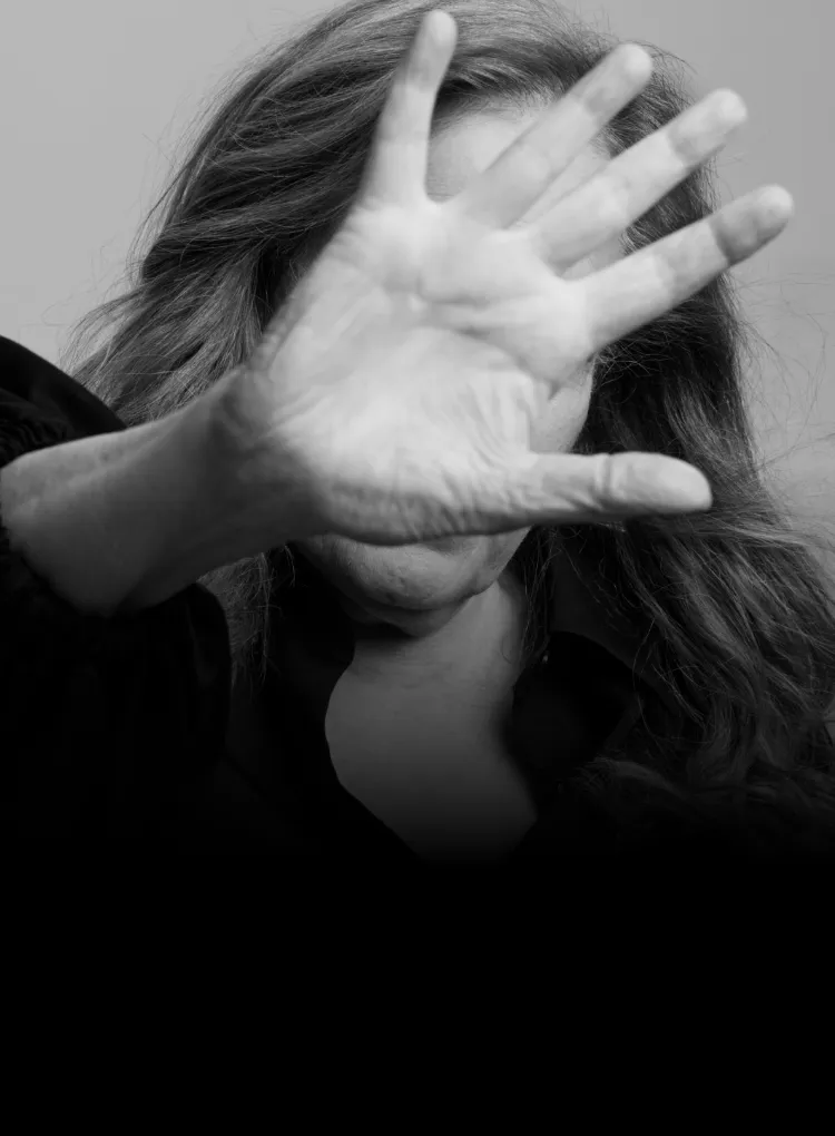 Jodi, a real person living with bronchiectasis (BE), blocking her face with her hand.